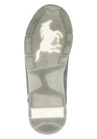 Semelle en caoutchouc transparent avec grip texturé, présentant le contour d'un cheval blanc et l'étiquette "MUSTANG True Denim" sur le côté.