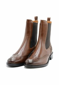 Stivali alla caviglia in pelle marrone con pannelli laterali elastici, dettagli decorativi brogue, finitura liscia e tacco basso impilato.