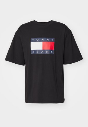 Camiseta de manga corta negra con un logotipo rectangular de Tommy Jeans que presenta bloques de color blanco, rojo y azul marino en el pecho.