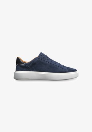 Marineblauwe suede sneakers met een witte rubberen zool, platte veters en een zwart leren hakaccent. Eenvoudig, design met een lage profiel.