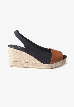 Juodas drobės platformos sandalai su rudomis odinėmis pirštų dalimis ir pintu jūrinio šiaudo kulnu. Slingback dizainas su atvira pirštų dalimi.