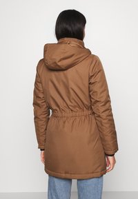 Brown, padded parka jacket with a cinched waist, adjustable hood, and long sleeves, featuring a smooth texture and mid-length design.