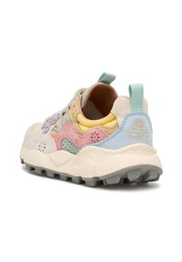 Sneaker multicolore con pannelli in suede e mesh pastello, una suola di crema imbottita e un tab di tacco blu testurizzato con accenti di branding.