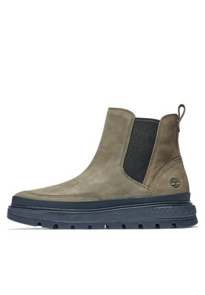 Enkellaars van bruin leer met zwarte elastische zijpanelen, dikke zwarte zool, trekkoord aan de hiel en Timberland-logo aan de buitenzijde.