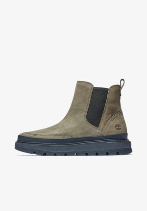Botte Chelsea en cuir marron montant à la cheville avec panneaux latéraux élastiques noirs, semelle noire épaisse, languette à l'arrière et logo Timberland sur le côté extérieur.