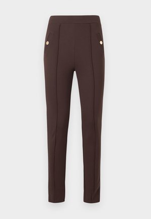 Pantalon marron slim avec coutures verticales et poches avant inclinées, chacune ornée d’un unique bouton rond doré.