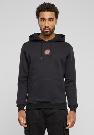 Schwarzer Hoodie aus weichem Material, mit Kängurutasche, verstellbarem Kapuzenzug und einem runden roten und weißen "BALLIN 23" Logo auf der Brust.