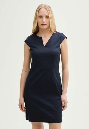 Marineblauwe fitted jurk met kapmouwen, V-hals en zijspleet. Gemaakt van gladde stof met een getailleerde silhouet en verticale naden.