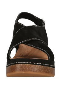 Svarta lädersandaler med korsade remmar, öppen tå, vadderad innersula och korkplattformssula. Vita sömmar som accentuerar kanten.