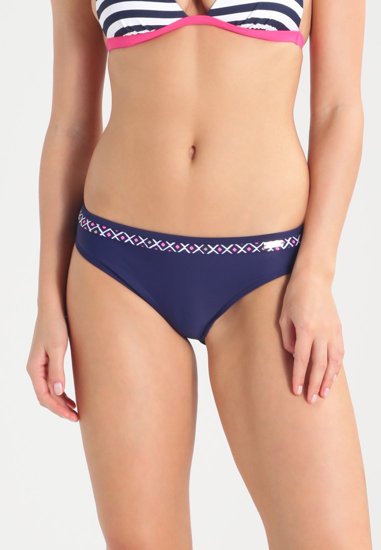 Tamsiai mėlynos bikini kelnaitės su dekoratyvia juosta, puošta rožiniais ir baltais geometriniais raštais bei mažu logotipo akcentu šone.