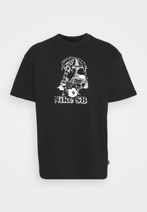 Svart t-shirt med en vit grafisk design av en palm och en golfbil, med "Nike SB" text nedanför illustration.