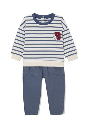 Gestreifter Pullover mit langen Ärmeln in Creme und Marineblau mit roter "B"-Stickerei, kombiniert mit einfarbigen Marineblau-Hosen mit zwei Fronttaschen.