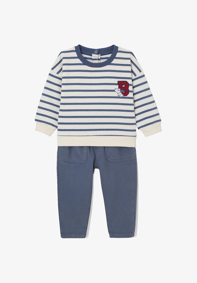 Gestreifter Pullover mit langen Ärmeln in Creme und Marineblau mit roter "B"-Stickerei, kombiniert mit einfarbigen Marineblau-Hosen mit zwei Fronttaschen.