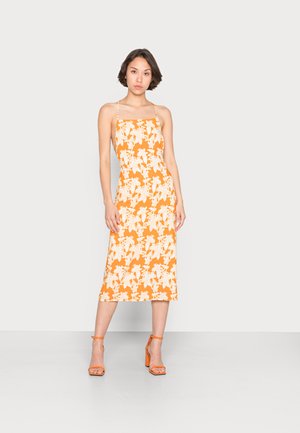 Vestido midi floral laranja com decote quadrado e alças finas. Apresenta um padrão de flores brancas e uma silhueta reta. Acentuado com sandálias de salto laranja.