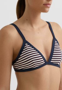 Háromszög alakú bikini felsőrész tengerészkék és krémszínű csíkokkal, széles, kontrasztos pántokkal és texturált szövetmintával.