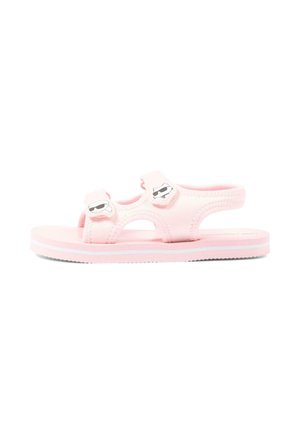 Sandalo rosa per bambini con doppie cinghie in Velcro che mostrano volti di cartoni animati sorridenti con occhiali da sole e suola a strisce bianche.