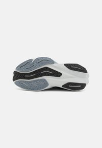 Shoe sole featuring a textured black, gray, and light blue design with deep grooves for traction and a rounded shape.