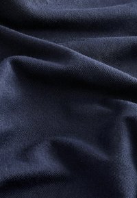 Marine stof met een zachte, gestructureerde oppervlakte, die golven en plooien vertoont, gemaakt van een lichtgewicht materiaal geschikt voor kleding.