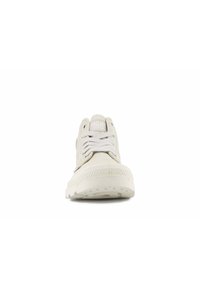 Zapatillas de lona gris claro con suela de goma texturizada, puntera redonda y dos pares de ojales. Incluyen cordones blancos y una lengüeta acolchada.