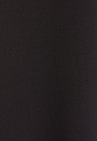 Gros plan d'un tissu gris foncé avec une texture tissée serrée et un motif diagonal subtil, montrant des fils fins et une surface uniforme.