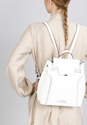 Biały skórzany plecak z czarnymi akcentami, o strukturalnym kształcie, z górną klapą, regulowanymi ramionami i wyraźnym detalem ściegów. Złote logo z przodu.