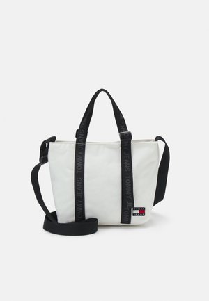 Sac fourre-tout Tommy Jeans blanc avec deux bretelles noires et un petit patch logo dans le coin inférieur droit à l'avant.