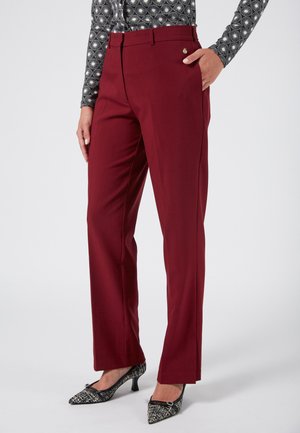 Burgundy tailored trousers with a slim fit, flat front, and side pockets. Made from smooth fabric, featuring a small metallic accent.