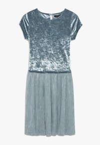 Velvet dress in light blue with short sleeves, round neckline, and a pleated skirt featuring a subtle shimmer. Keyhole back closure.