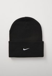 Juodas megztinis kepurė su sulenkiamu kraštu ir baltu Nike swoosh logotipu. Pagaminta iš švelnios, tekstūruotos medžiagos ir puikiai priglunda.