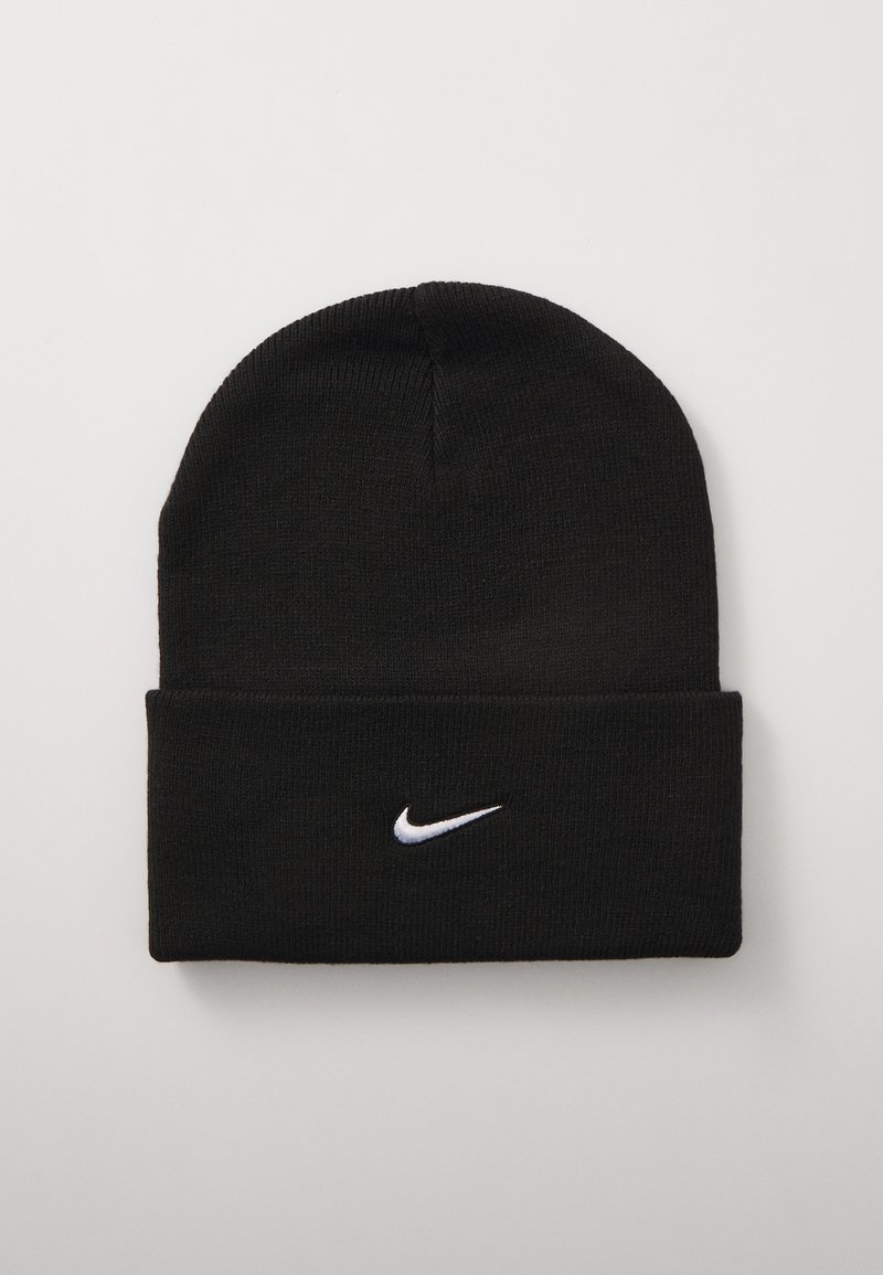 Juodas megztinis kepurė su sulenkiamu kraštu ir baltu Nike swoosh logotipu. Pagaminta iš švelnios, tekstūruotos medžiagos ir puikiai priglunda.