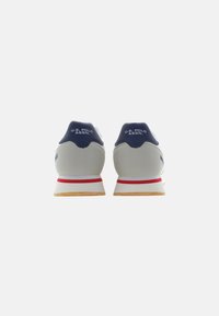 Sneaker navy e grigie con tomaia in tessuto texture, dotate di una suola intermedia bianca, dettagli rossi e una suola in gomma con logo sul tallone.