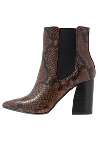 Bottine marron et noire à imprimé serpent, avec un bout pointu, des panneaux latéraux élastiques et un talon noir épais. Texture lisse avec une finition brillante.