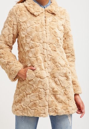 Beige falsk pelsjakke med et struktureret, shaggy design. Har en krave, frontlukning med knapper og sidelommer.