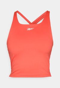 Rød idretts crop topp laget av glatt, elastisk stoff. Har et racerback-design og en liten hvit logo på forsiden.