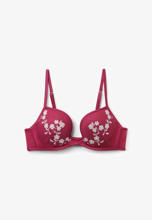 Diep roze gewatteerde beha met verstelbare bandjes en witte bloemenborduursel op beide cups, plat gelegd op een witte achtergrond.