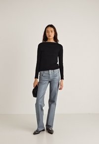 Mustast moodust sirge säärega helesinised teksad, must fitted pika käistega särk, must käekott ja mustade naeltega kontsakingad. Lihtne ja puhas disain minimaalse detailidega.