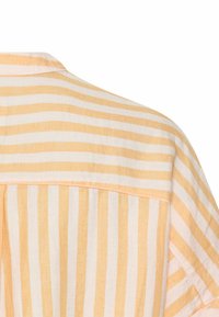 Gestreept shirt met afwisselend lichtgele en witte verticale strepen, voorzien van een zachte stof, ronde kraag en een plooi detail aan de achterkant.