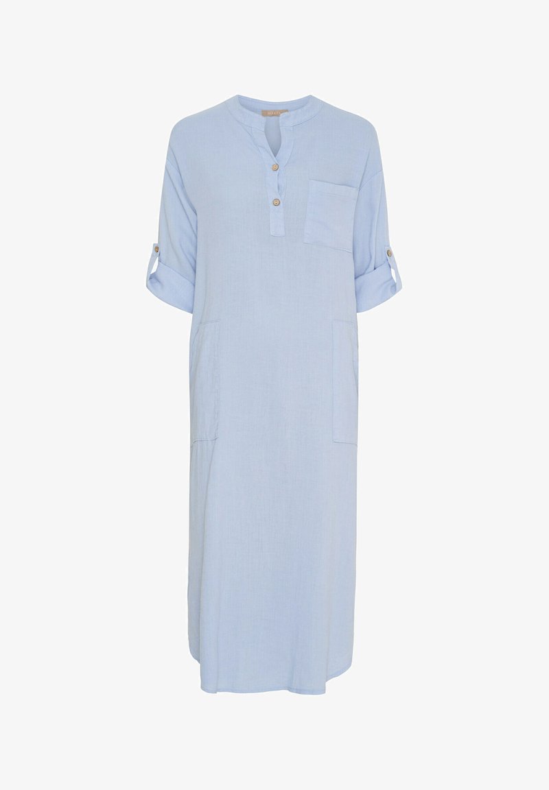 Lyseblå, linnedragt med rund halsudskæring, tre knapper, korte ærmer oprullet og sidelommer. Har en afslappet pasform.