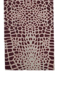 Woven scarf in beżowej bazie, z ciemnoczerwonym i brązowym abstrakcyjnym wzorem przypominającym print zwierzęcy. Krawędzie mają postrzępione wykończenie.