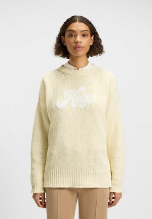 Maglione giallo lavorato a maglia con orlo a coste. Presenta un logo bianco "Hugo" sulla parte anteriore e un design con spalla cadente. Tessuto testurizzato con vestibilità ampia.