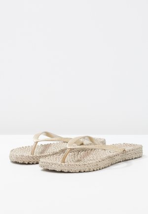 Beige vævede flip-flops med glitrende guldstropper, der har en flad sål og struktureret overflade.
