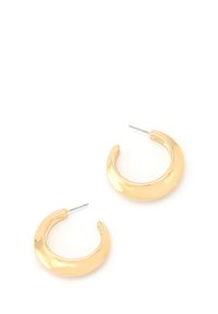 Une paire de boucles d'oreilles créoles en or brillant en forme de croissant avec des tiges en argent sur un fond blanc.