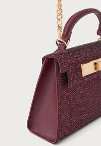 Geanta burgundy cu o formă structurată, decorată cu rhinestones texturate, și metal hardware de culoare aurie, având un bretea din lanț. Finisaj neted.