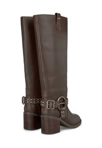 Botas de cuero marrón hasta la rodilla con puntera redonda, caña ancha, tacón grueso y detalles decorativos de hebilla y tira con tachuelas.