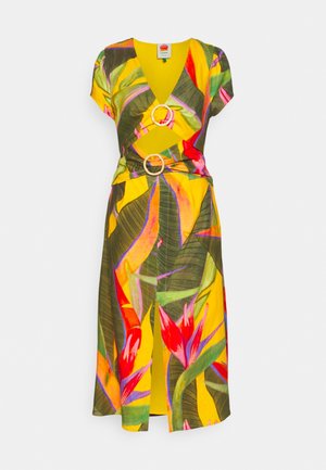 Żółta sukienka midi z tropikalnym wzorem liści i kwiatów, krótkie rękawy, dekolt w serek oraz dwa okrągłe klamry na biuście i w talii.