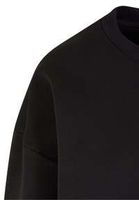Felpa nera con colletto a girocollo rigato e tessuto testurizzato. Il design include una vestibilità rilassata con cuciture delle spalle cadenti.