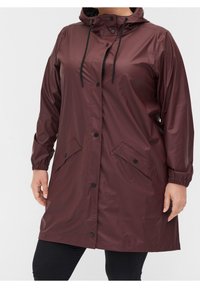 Vínová voděodolná pláštěnka s kapucí, elastickými manžetami a drukovými zapínáním; má dvě boční kapsy a hladký, lesklý povrch.