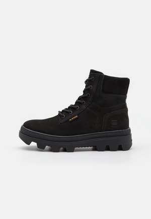Bottine noire à lacets avec semelle épaisse à crampons, col rembourré et logo G-Star sur le côté et la languette.