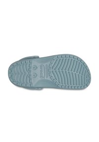 Ljusblå gummisul av en Crocs sandal, med texturerade mönster och logotyp. Slät yta med räfflade kanter för grepp.