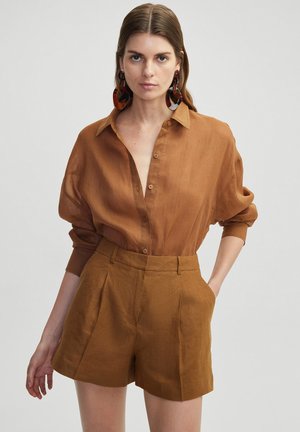 Bruin, lichtgewicht knoopshirt met een kraag en opgerolde mouwen, gecombineerd met bijpassende hoge shorts. Textuurdetail in de stof.